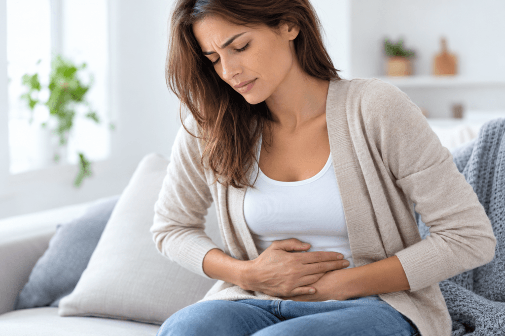 Mujer con dolor abdominal en el sofa